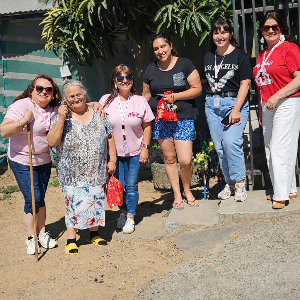 Voluntarias de Alma de Mujer junto a una vecina del sector