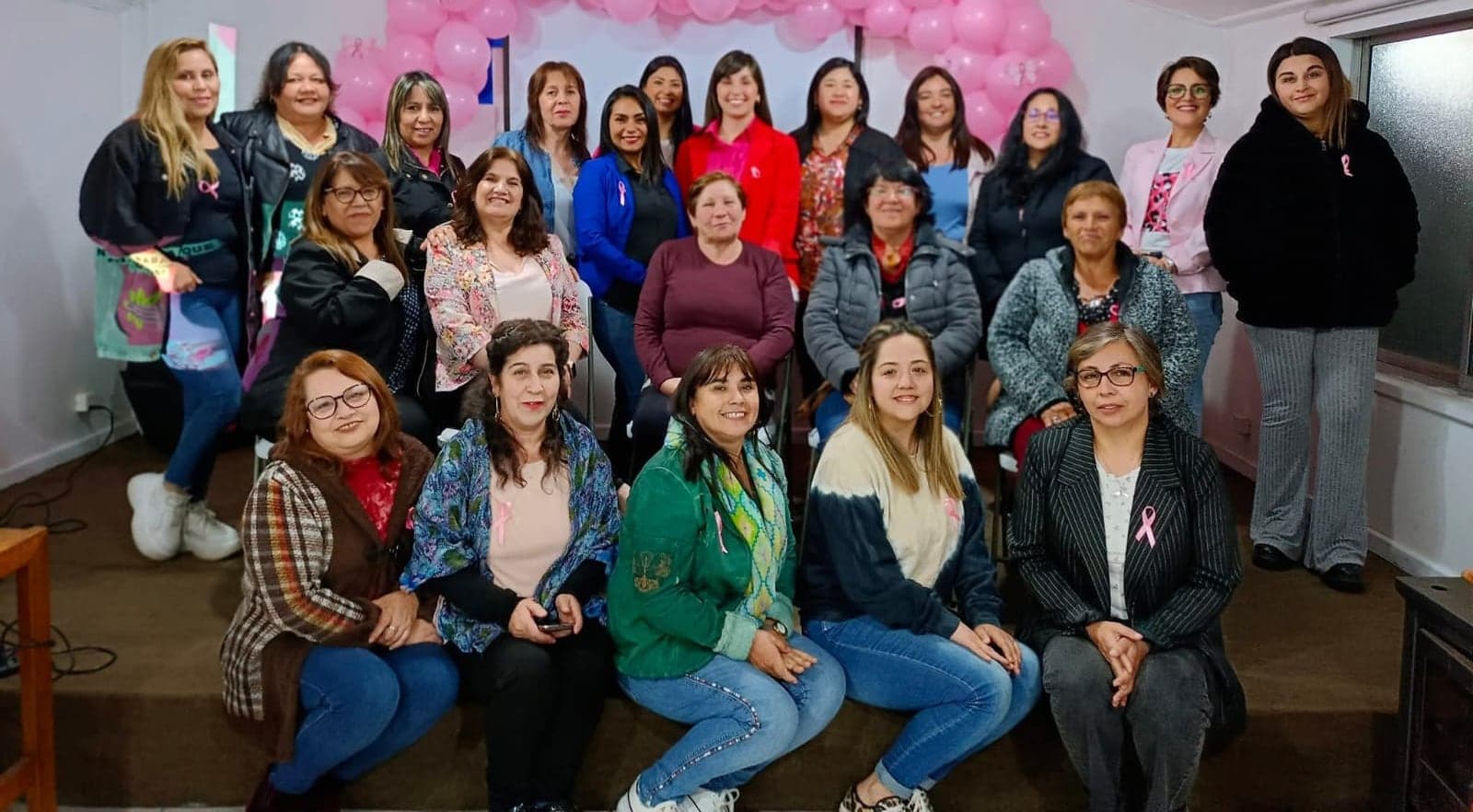 Mujeres con cintas rosadas en un encuentro de prevención de Alma de Mujer